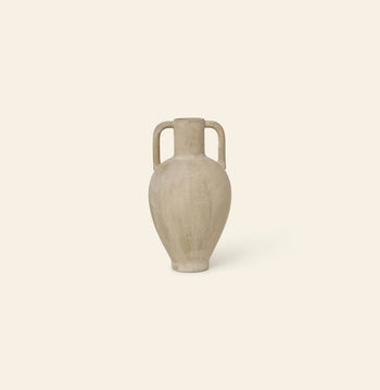 The ferm LIVING Ary Mini Vase L, a beige ceramic amphora inspired by ancient Greek vases with two vertical handles and a narrow neck, sits on a light cream background—crafted in textured glazed stoneware.