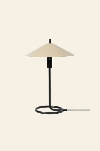 The ferm LIVING Filo Table Lamp features a powder-coated iron black stem and a beige cone shade, offering modern style to any room. Its circular base and exposed cord add to its sleek look, perfect for bright spaces.