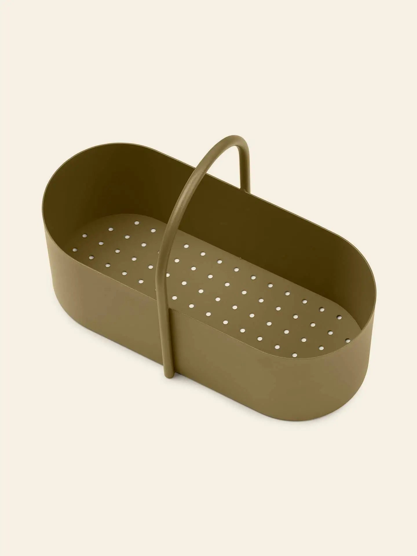 The ferm LIVING Grib Toolbox by ferm LIVING is an olive green, oval-shaped organizer with a slim handle and perforations at the base, displayed on a plain light beige background.
