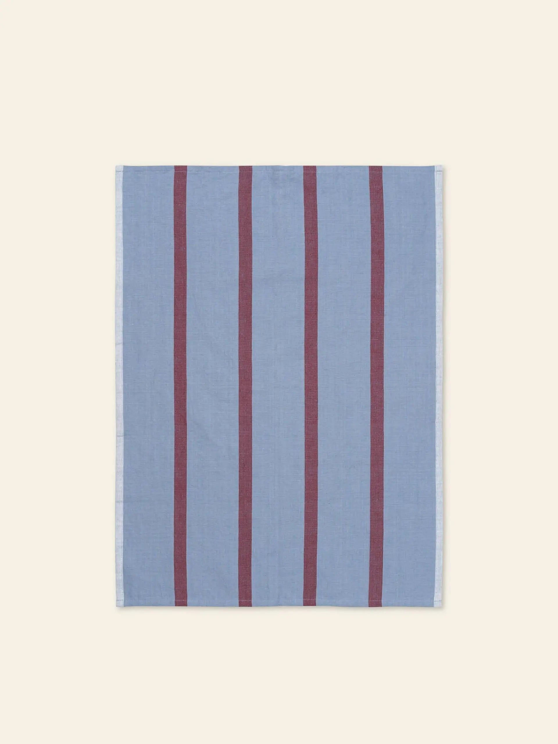 The ferm LIVING Hale Tea Towel, by ferm LIVING, is a square, light blue cloth featuring four evenly spaced vertical maroon stripes, shown on a plain cream background.