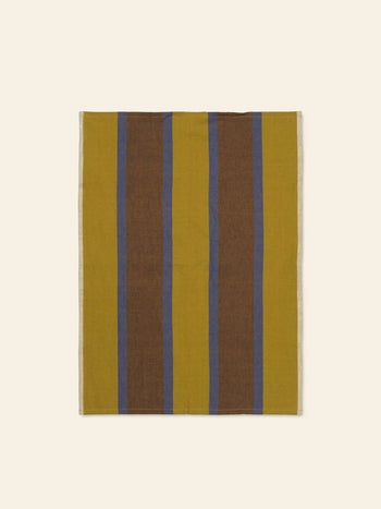 The ferm LIVING Hale Tea Towel by ferm LIVING features vertical stripes in mustard yellow, brown, and blue, shown flat on a light beige background.