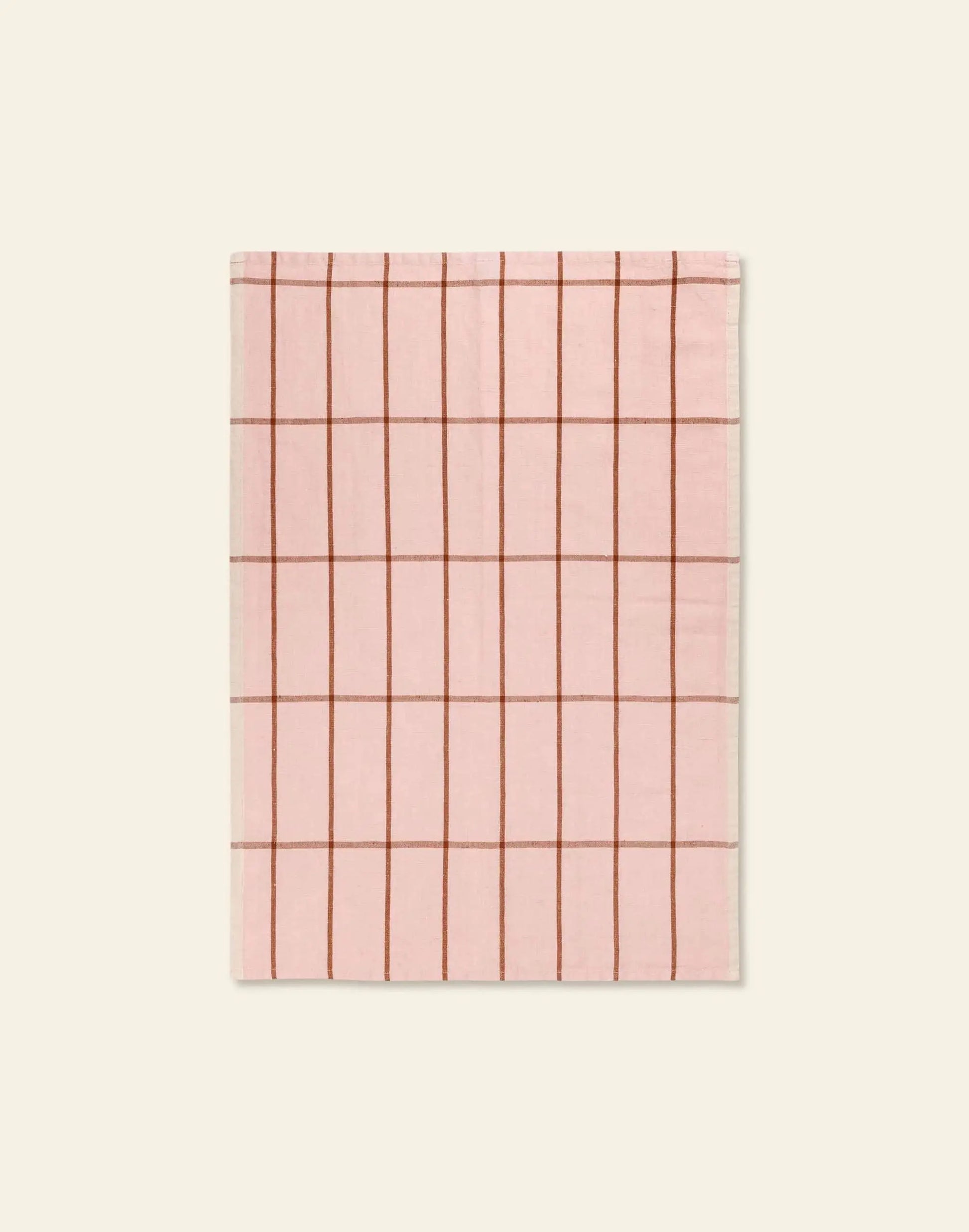 The ferm LIVING Hale Tea Towel by ferm LIVING is a pink rectangular towel featuring a grid of thin brown lines, shown flat on a beige background.