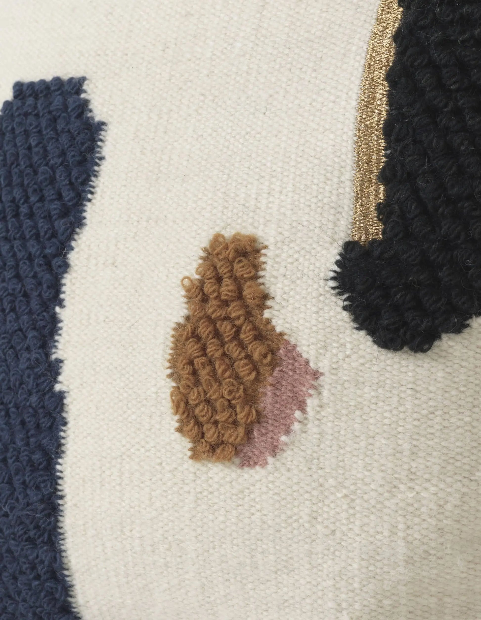 Close-up of the ferm LIVING Loop Cushion, crafted from New Zealand wool with tufted embroidery in navy, brown, pink, and black on a cream backdrop—highlighting abstract shapes and contemporary stitched details by ferm LIVING.