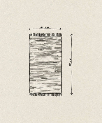 The ferm LIVING Melange Rug by ferm LIVING is a hand-drawn, easy-care rectangular rug with fringes on the short ends. It measures 60 x 100 cm, shown with labeled arrows on a textured off-white paper background.