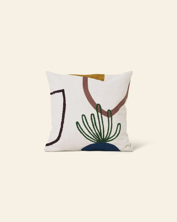 The ferm LIVING Mirage Cushion by ferm LIVING features a modern abstract design with embroidered shapes in brown, gold, blue, green, and black on a cream background—an elegant decorative pillow displayed on a plain cream backdrop.