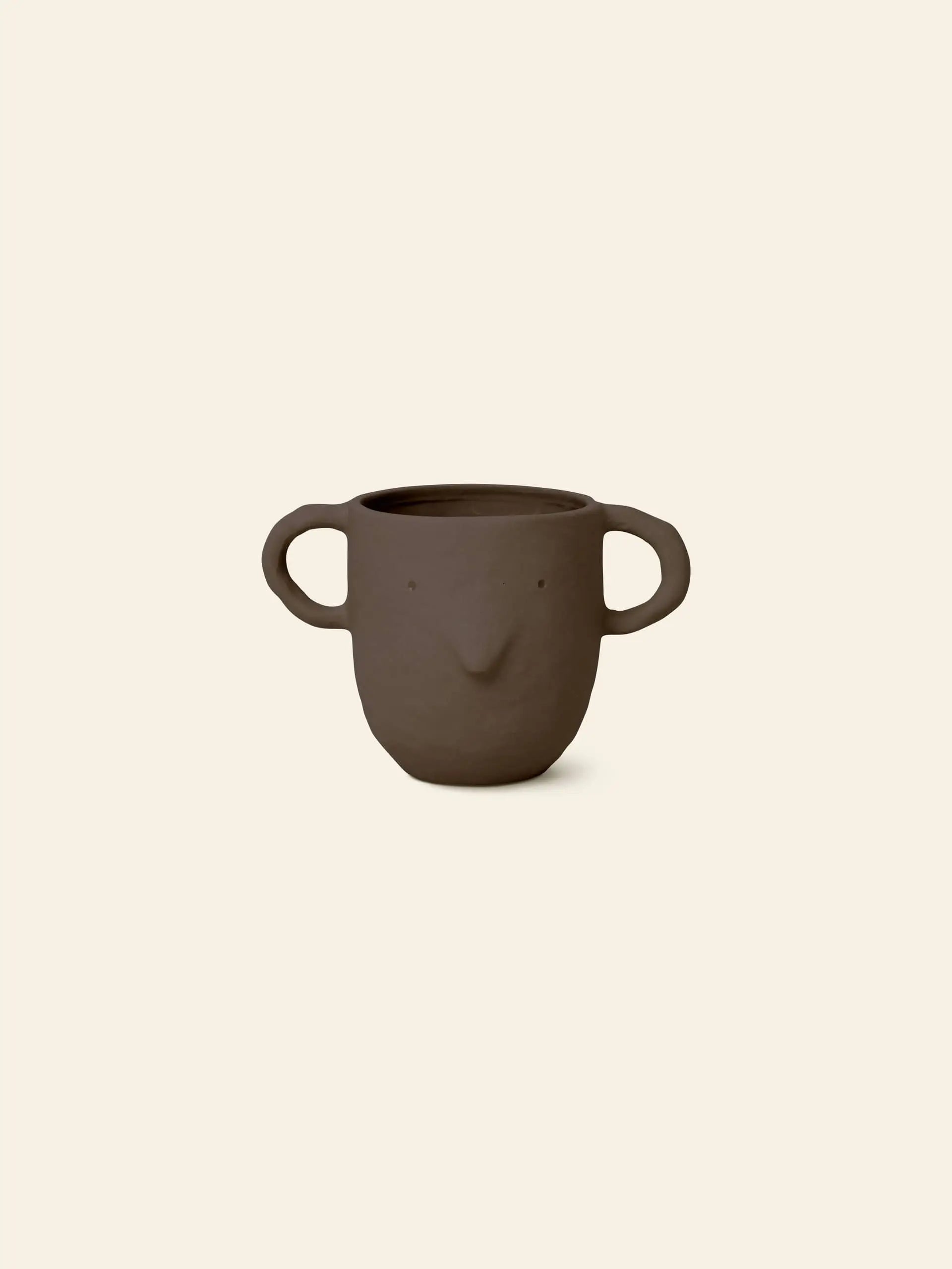 The ferm LIVING Mus Plant Pot, Large, features a brown ceramic build with two big mouse-shaped handles and a simple face design—an ideal quirky accent for your ferm LIVING-inspired space.