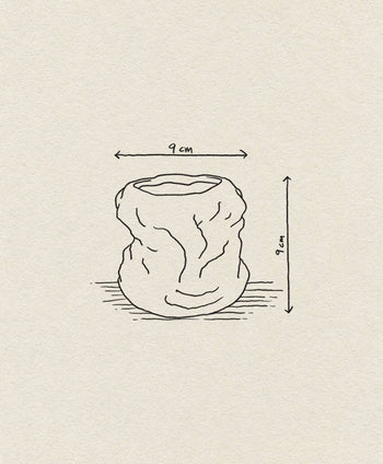 Line drawing of the ferm LIVING Tuck Scented Candle, a crumpled, cylindrical vessel inspired by stoneware glaze, 9 cm high and wide with dimension arrows, shown on a beige textured background. Brand: ferm LIVING.