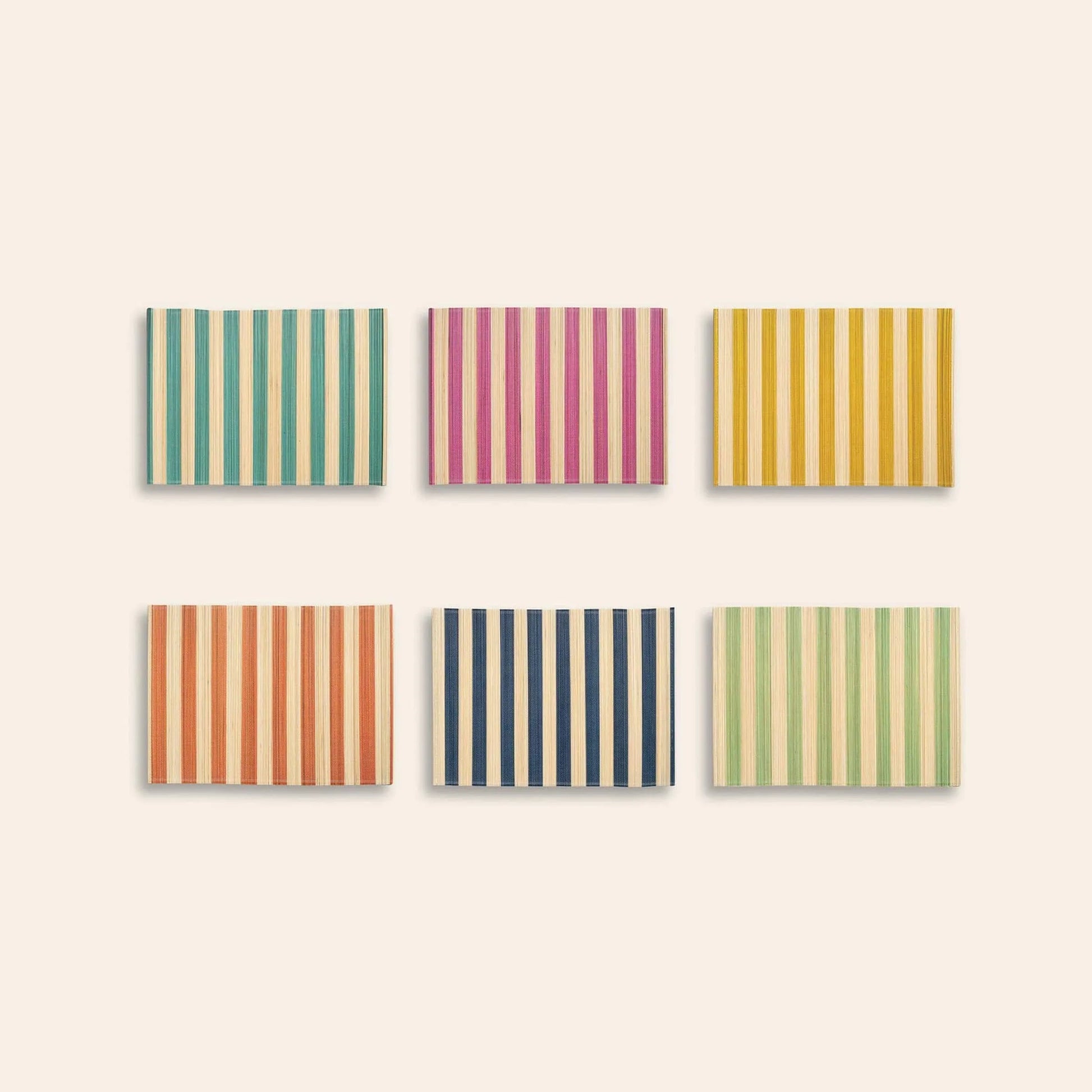 Six vibrant &klevering Bay Placemats are shown in two rows of three, each with vertical stripes in teal, pink, yellow (top row) and orange, navy blue, light green (bottom row), all on beige. Set of 6 by &klevering.