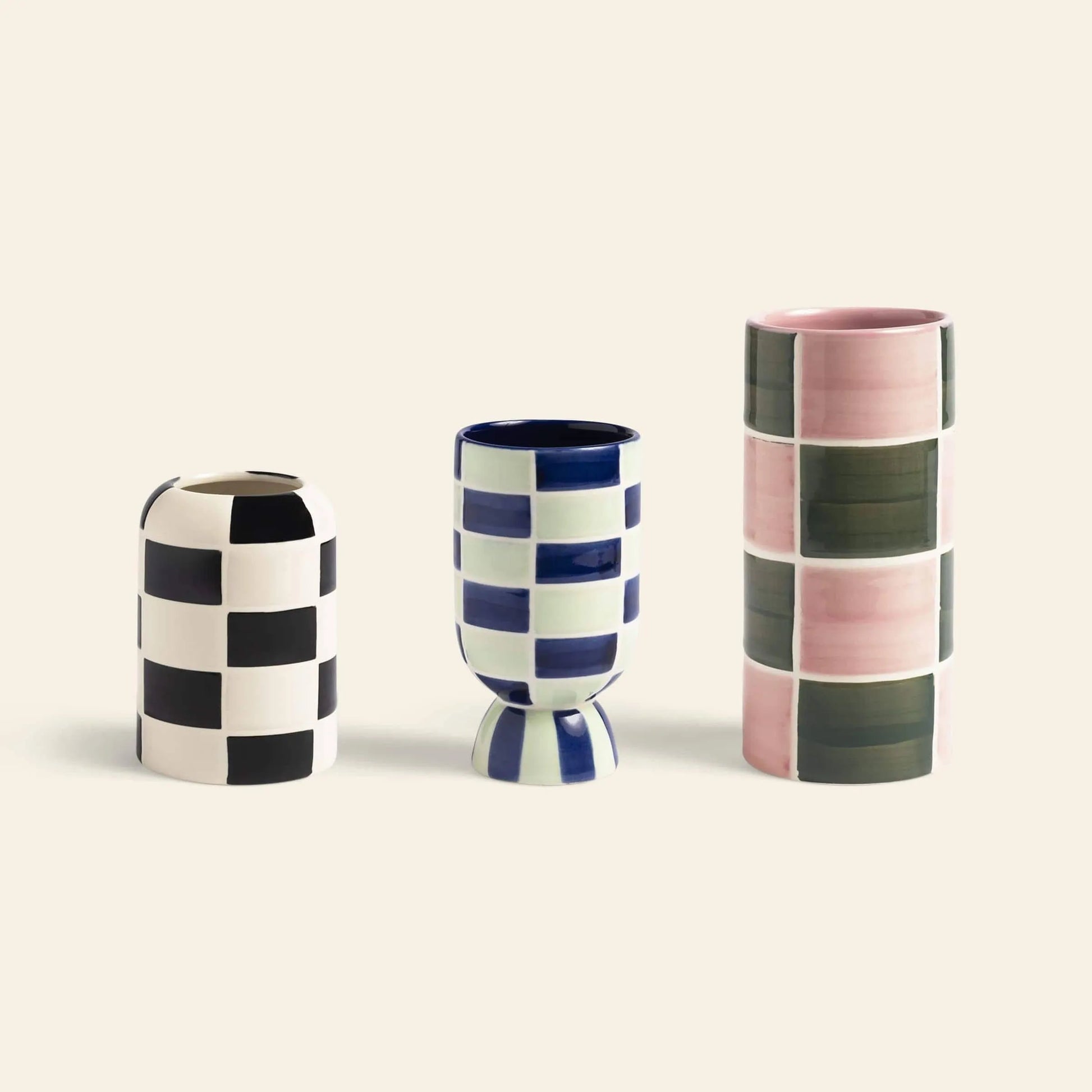 The &klevering Carré Vase, Set of 3 by &klevering features bold checkered designs—one black and white, one blue and white with a rounded base, and one tall with pink and green squares—striking decorative pieces.