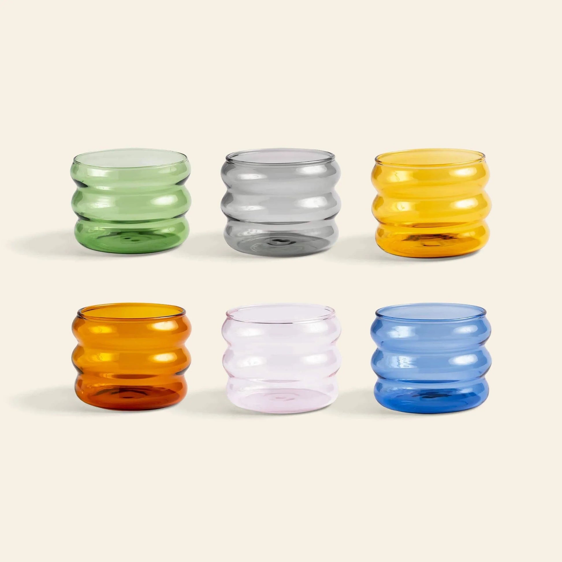 The &klevering Chubby Glass Set of 6 features vibrant green, gray, yellow, orange, pink, and blue glasses with unique edges from &klevering, displayed in two rows on a light beige background.