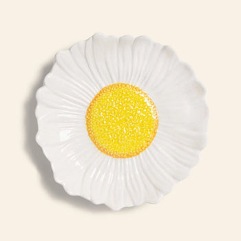The &klevering Daisy Bowl by &klevering features textured white ceramic petals and a bright yellow center, making it perfect for garden dinners or summer picnics.