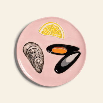 The &klevering De La Mer Plate, Set of 4, features hand-painted clam shell, mussel shells, and lemon wedge designs on cream ceramic, adding oceanic charm to your table.