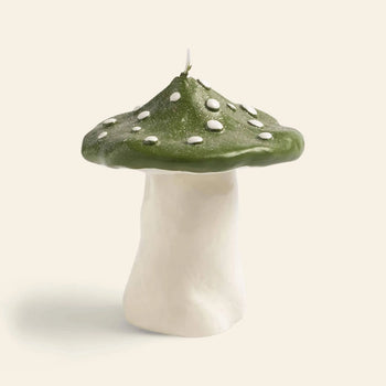 The &klevering Dots Mushroom Candle by &klevering features a white stem and a green cap with white spots, creating an enchanting ambiance against a plain, light background.
