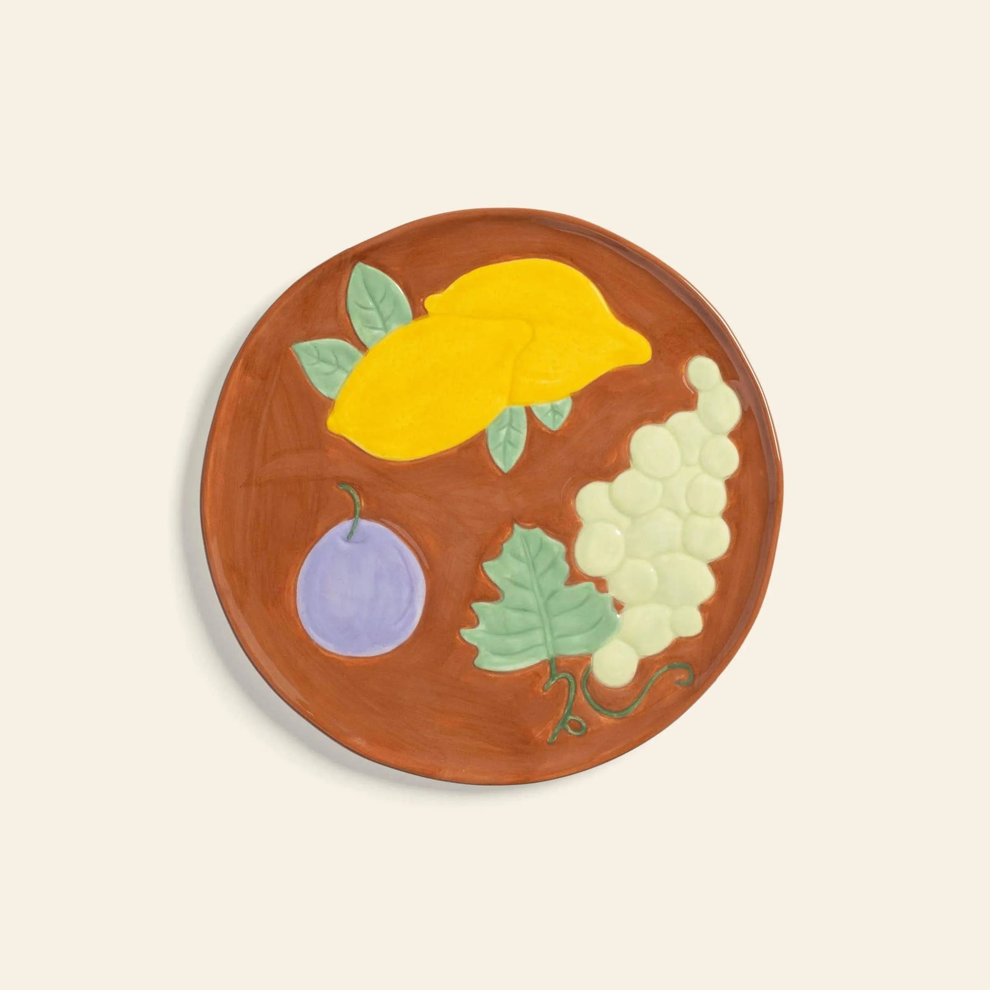 The &klevering Fruitful Plate, Set of 4, by &klevering features ceramic plates with a brown background and colorful fruit motifs including mangoes, grapes, plums, and green leaves—perfect for adding vintage charm to your table.
