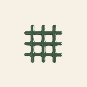 The &klevering Grid Trivet by &klevering is a green, glossy trivet with a geometric design, rounded edges, and four square openings. It is centered on a plain, light beige background.