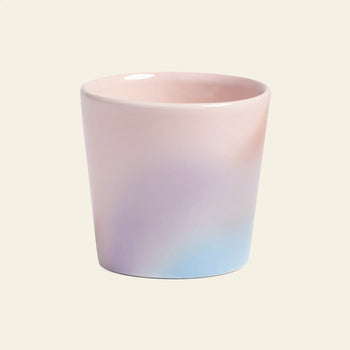 The &klevering Hue Mug Small, Set of 4 by &klevering features ceramic mugs with a smooth pastel gradient in pink, purple, and light blue tones, displayed against a plain beige background.