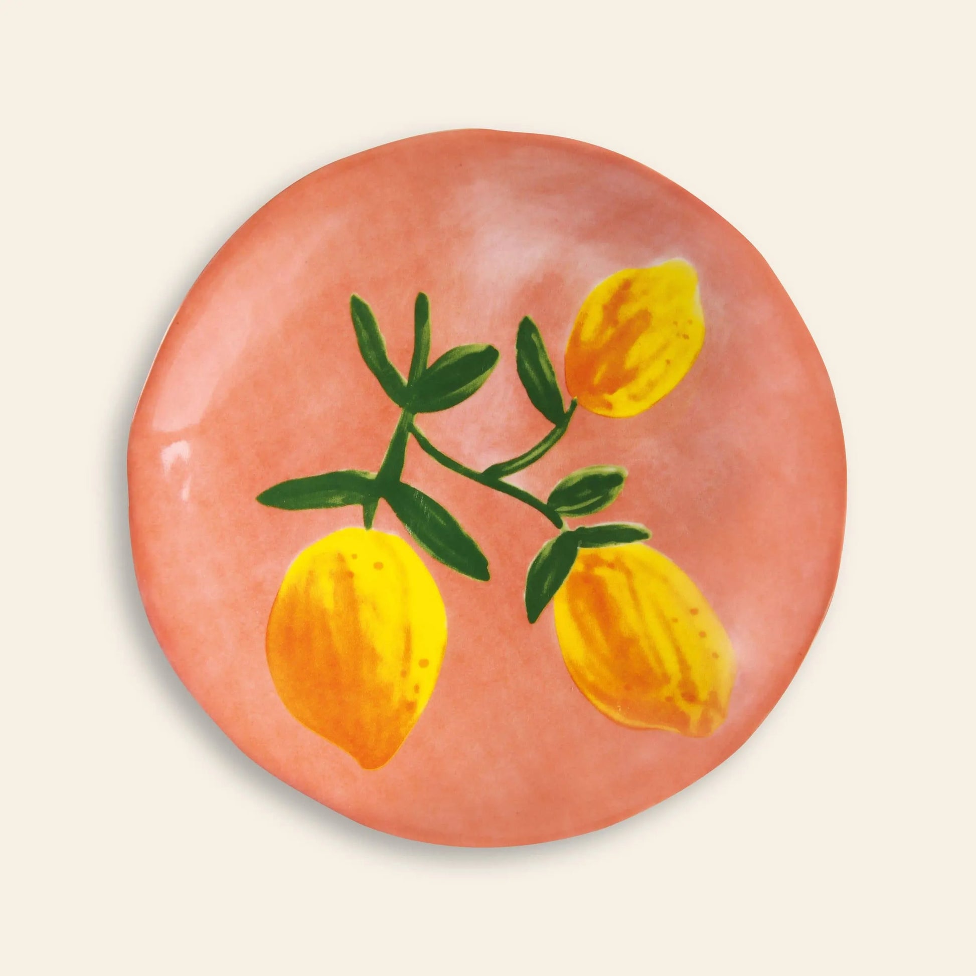 The &klevering Lemon Plate Set of 4 features round ceramic plates with a pinkish-orange background and a painted design of three yellow lemons with green leaves—ideal for bringing color to your summer table.