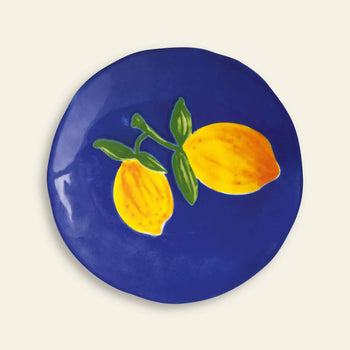 The &klevering Lemon Plate, Set of 4, features round ceramic plates with a deep blue background and bright yellow lemons—ideal for bringing a fresh, summery vibe to your table.