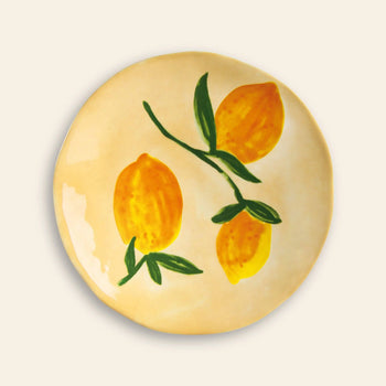 The &klevering Lemon Plate, Set of 4 by &klevering features round ceramic plates with light beige backgrounds and hand-painted yellow lemons with green leaves—ideal for adding a fresh, summery accent to your table.