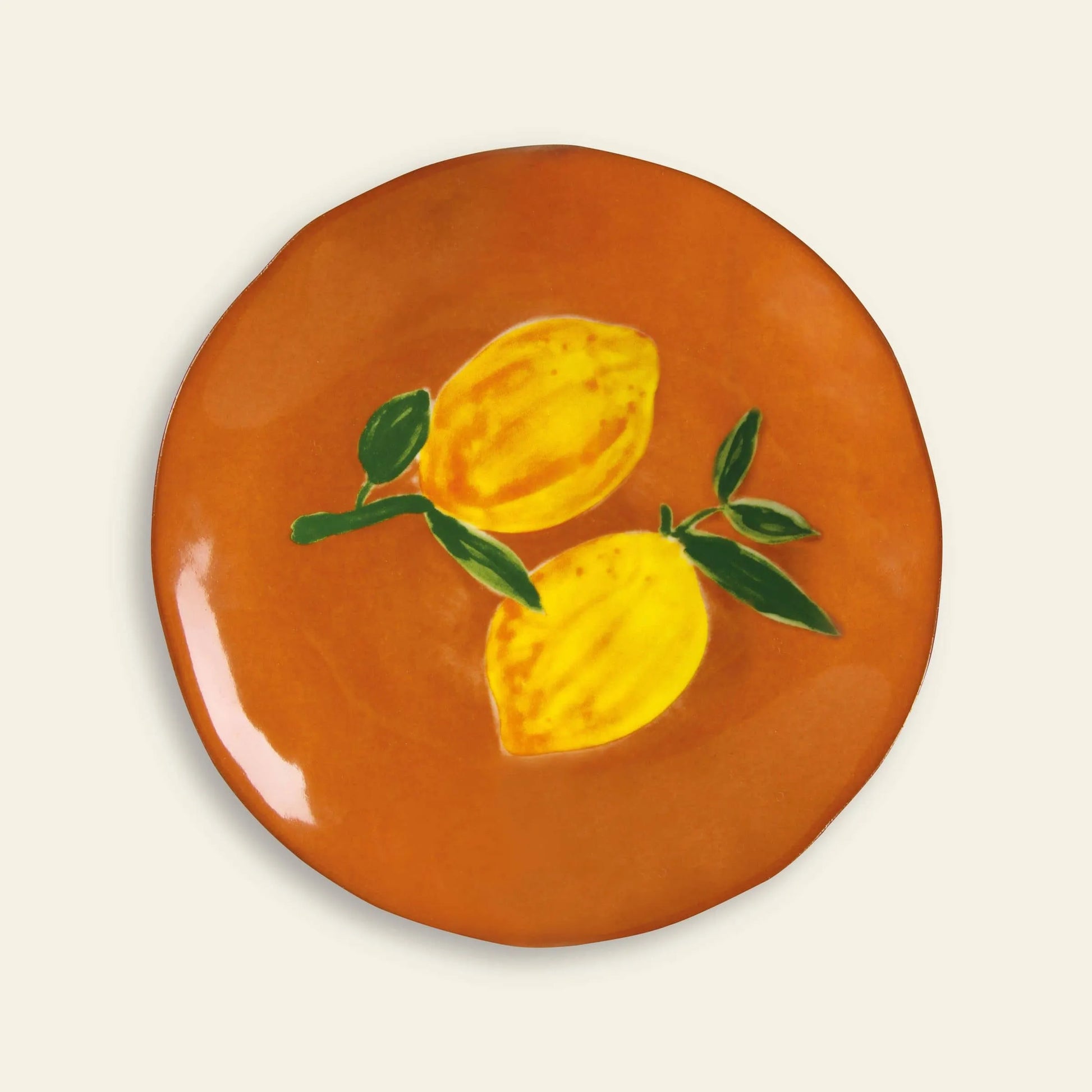 The &klevering Lemon Plate, Set of 4 by &klevering features round orange ceramic plates with a painted design of two yellow lemons and green leaves—ideal for adding a fresh, vibrant touch to your summer table.
