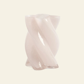 The &klevering Marshmallow Vase is a small, glossy light pink vase made from opaque glass with a twisted design, displayed against a plain, light beige background.