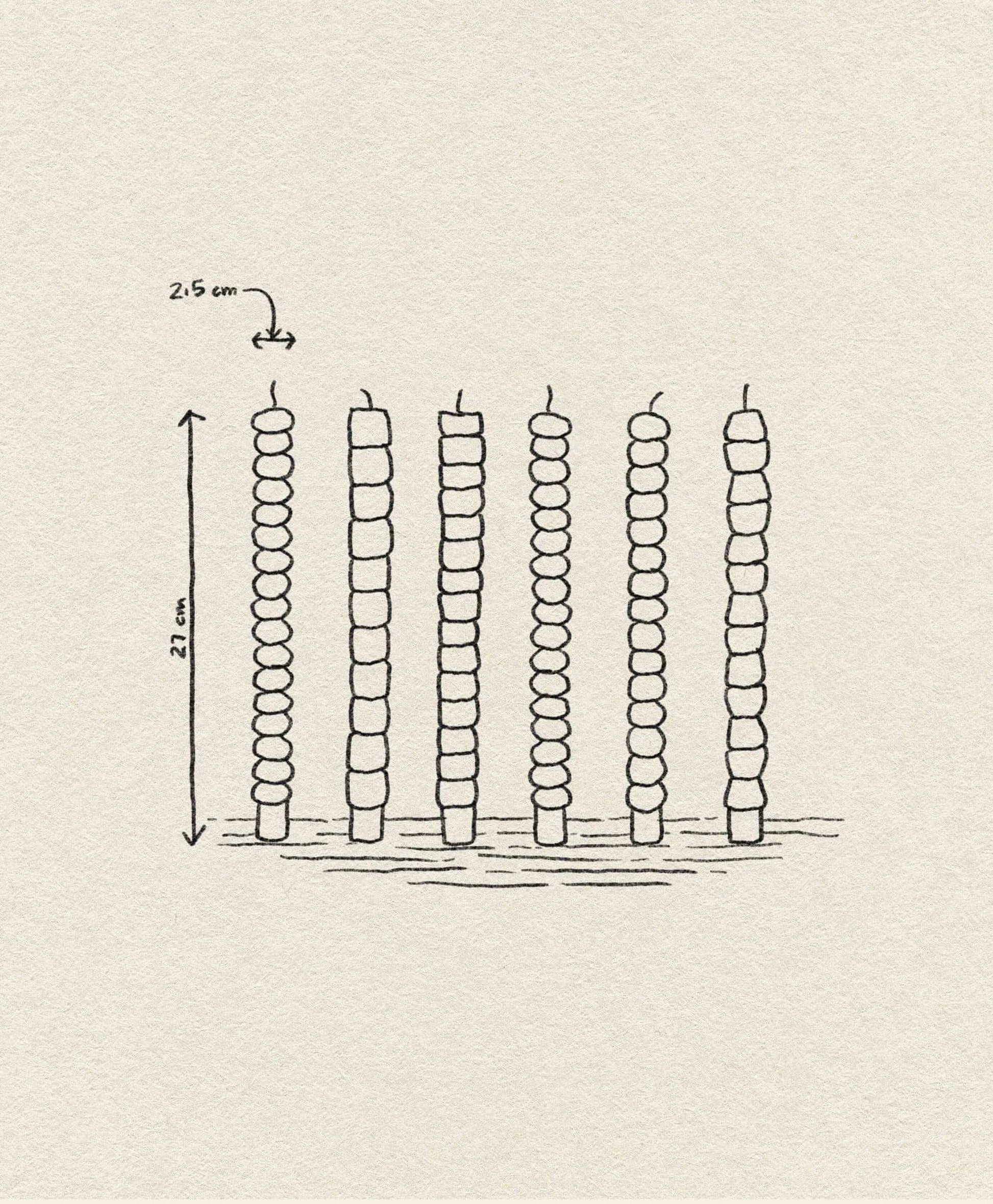 A hand-drawn illustration showcases the &klevering Pebble Candle Set of 6, each 21 cm tall and spaced 2.5 cm apart, with unique color accents—evoking handcrafted charm on a textured surface.