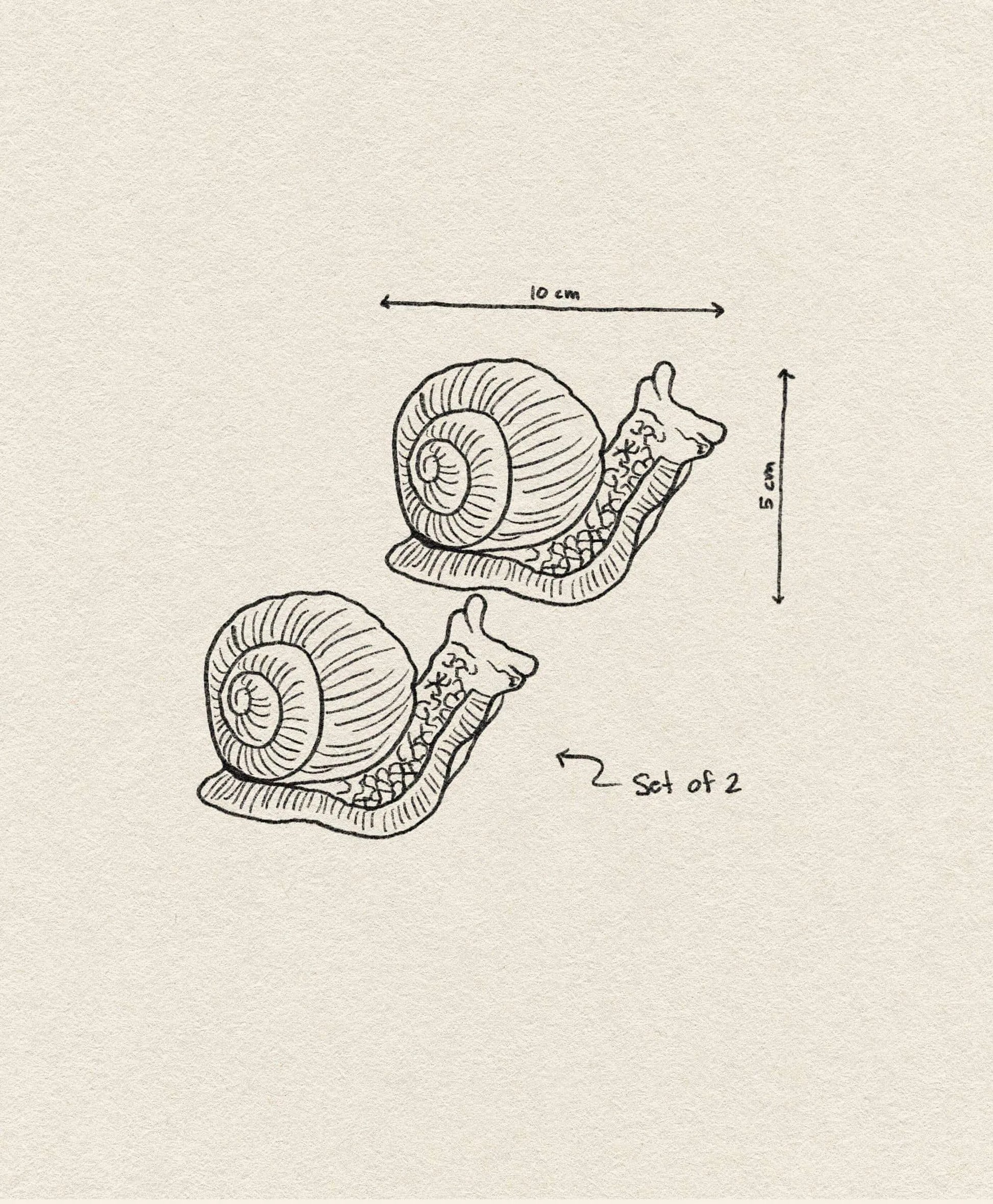 A whimsical &klevering Snail Salt & Pepper Set featuring two snails (10 cm wide, 8 cm tall)—the perfect quirky addition to your table from the &klevering brand.