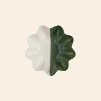 The &klevering Sun Bowl by &klevering features wavy edges and a half-cream, half-dark green design, shown from above on a light beige background—a striking modern accent for any space.