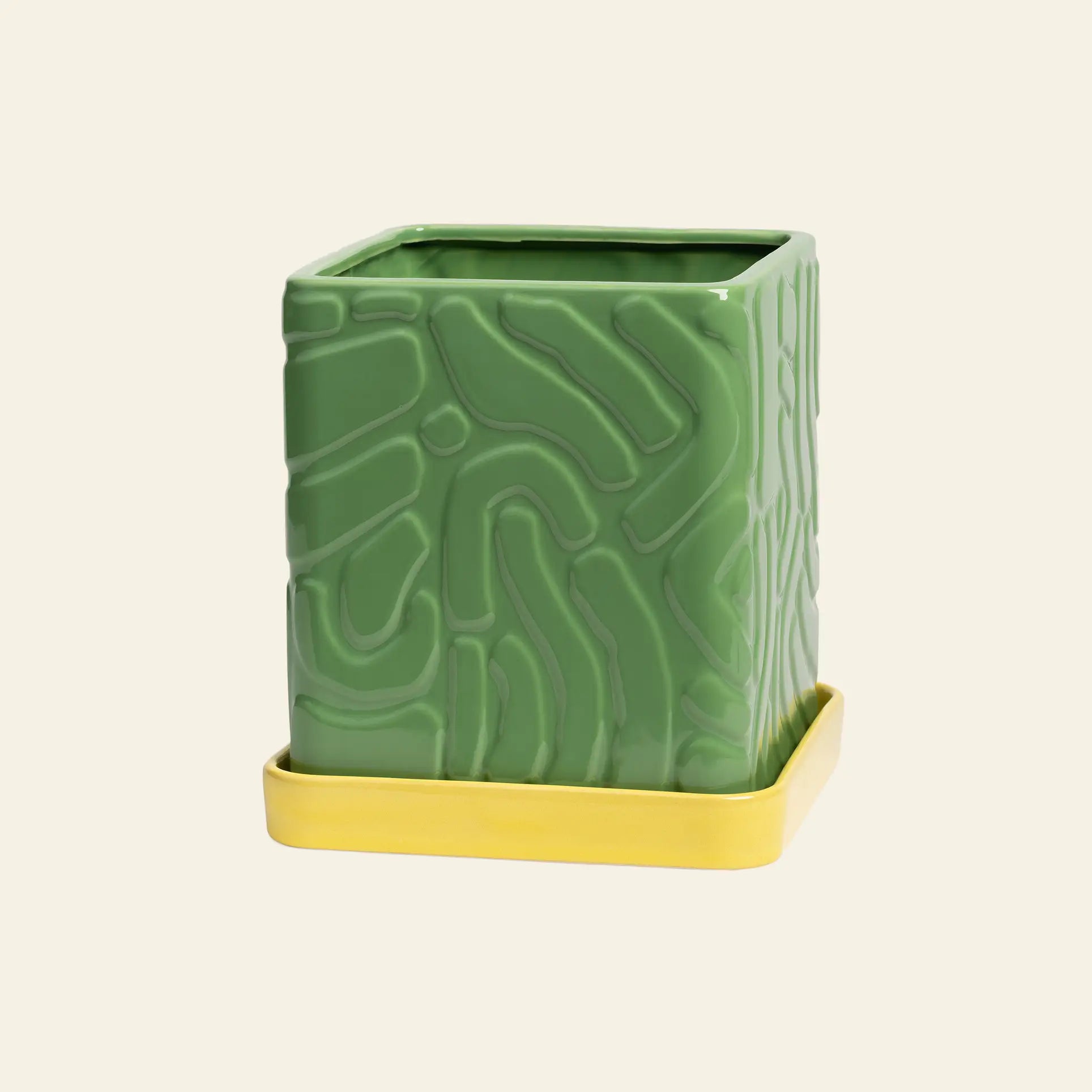 The &klevering Tribe Planter (Green), featuring an abstract textured pattern and square ceramic design, sits on a matching yellow saucer by &klevering, set against a plain light background.