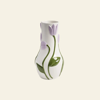 The &klevering Tulip Vase, Large, by &klevering, in white ceramic with embossed lavender tulip motifs and green leaves, makes a charming decorative accent against a plain light background.