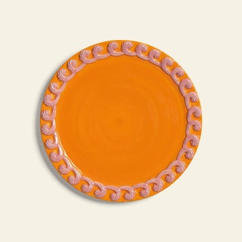 The &klevering Whipped Plate, Set of 4, features round orange plates with a decorative pink swirl candy-colored rim, from the &klevering collection, displayed against a light background.