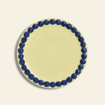 The &klevering Whipped Plate, Set of 4 features round pale yellow plates with a dark blue swirling border on a light beige background.