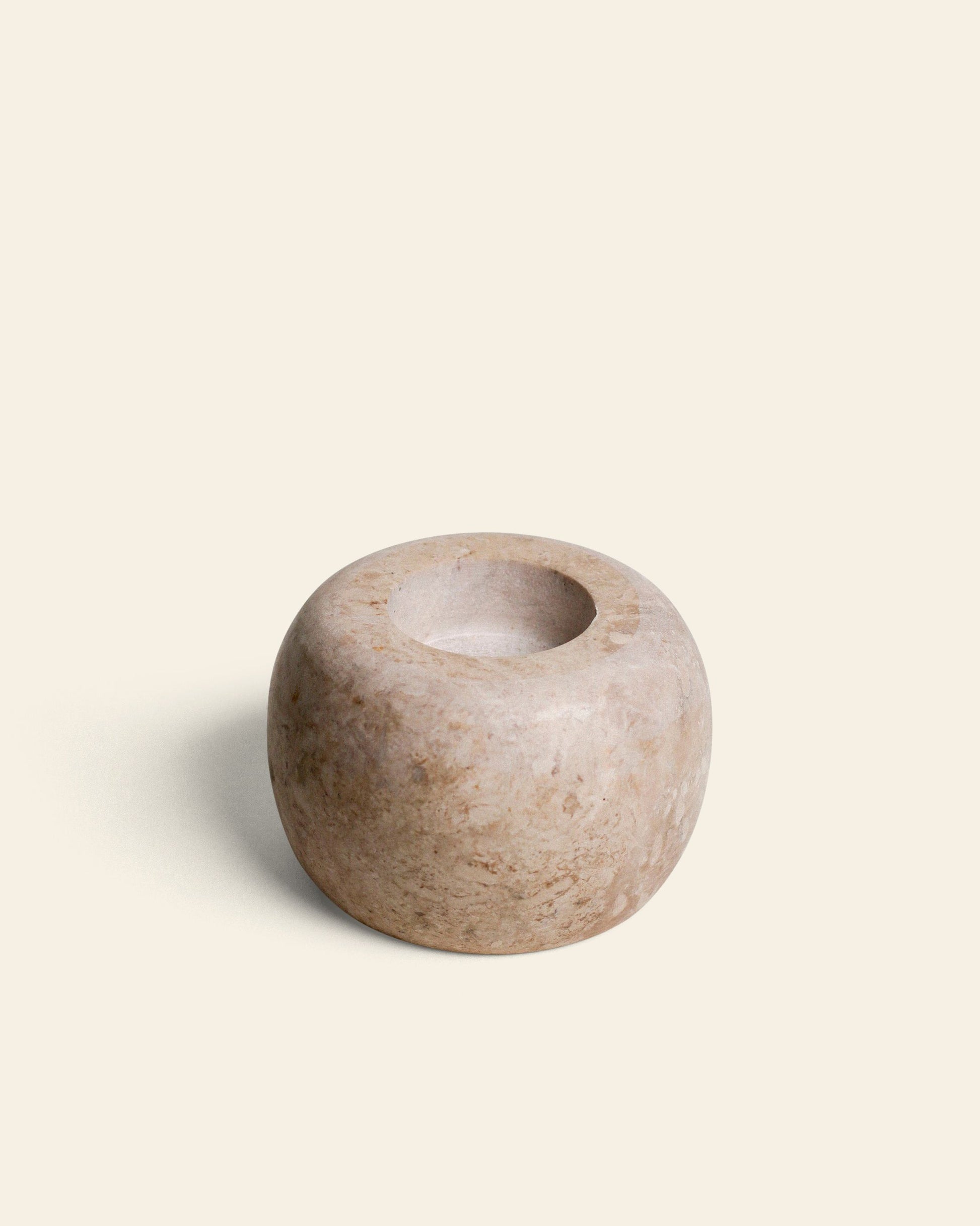 The stillgoods Abel Duo Holder is a round, smooth beige stone piece with a wide, shallow opening and polished surface showing natural patterns—ideal as a storage container or tealight candle holder.