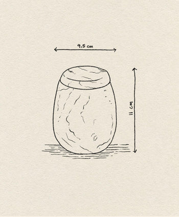 A hand-drawn illustration of the stillgoods Ecru Jar, an oval jar with a lid. Ideal for condiments or as an organizer, it measures 9.5cm wide by 11cm tall—dimensions shown with arrows and labels on beige textured paper.