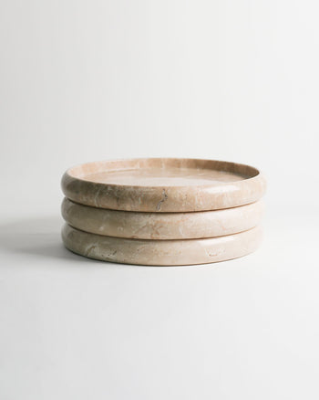 The stillgoods Harmony Tray by stillgoods features three stacked, round beige marble layers, adding sophisticated elegance to any home decor when displayed against a plain white background.