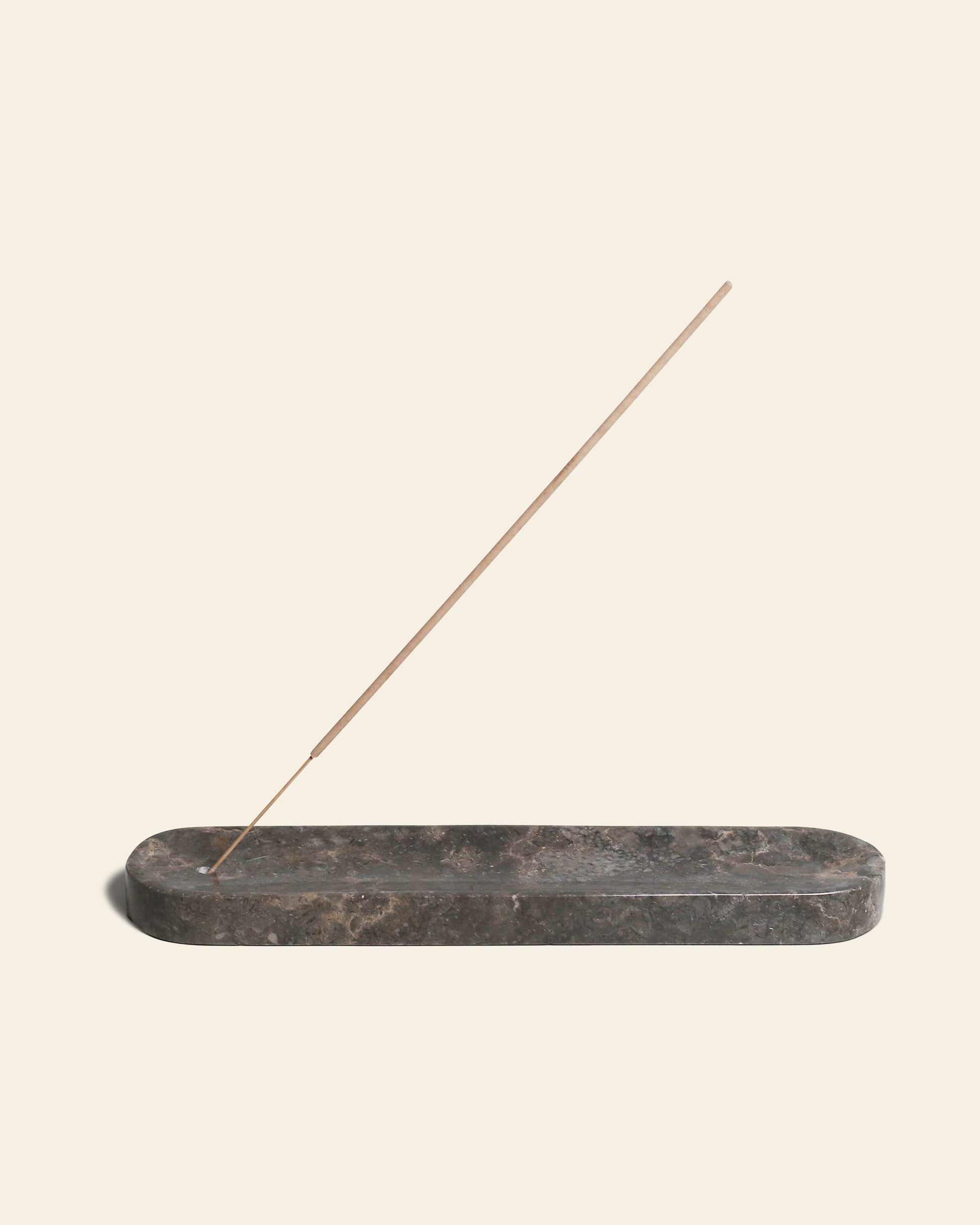 The stillgoods Horizon Incense Holder by stillgoods features a brown marble elongated design, holding an incense stick diagonally against a plain beige background—a versatile accent for any space.