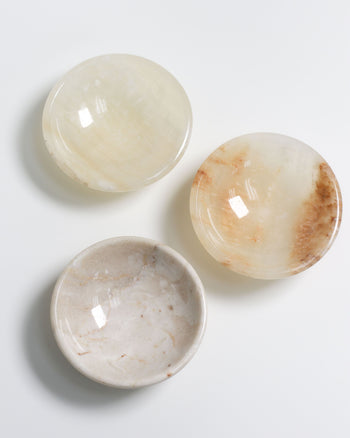 The stillgoods Luna Dish set by stillgoods features three round, shallow catch-all dishes with smooth, polished off-white and beige surfaces—ideal as mini trinket dishes for your essentials.